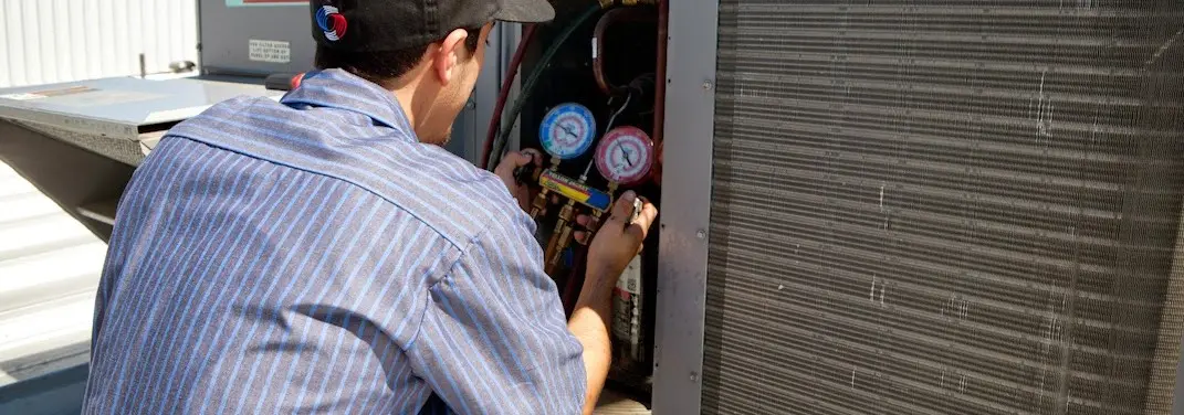 HVAC technician servicing a condenser unit in Cicero