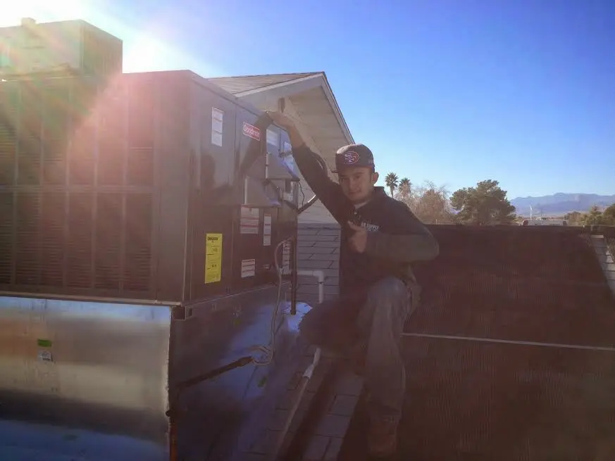 HVAC technician performing Heat Pump Repair on a rooftop unit in Cicero